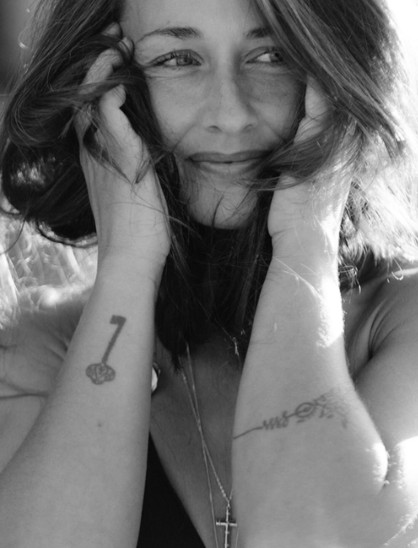 Retrato en blanco y negro de Verónica Calabuch sonriendo, con las manos en el pelo