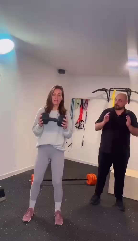 Sesión de entrenamiento personal en la sala: sentadilla con peso y corrección de la técnica